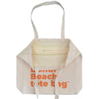 Close-up of a beige tote bag with a zipper pocket.