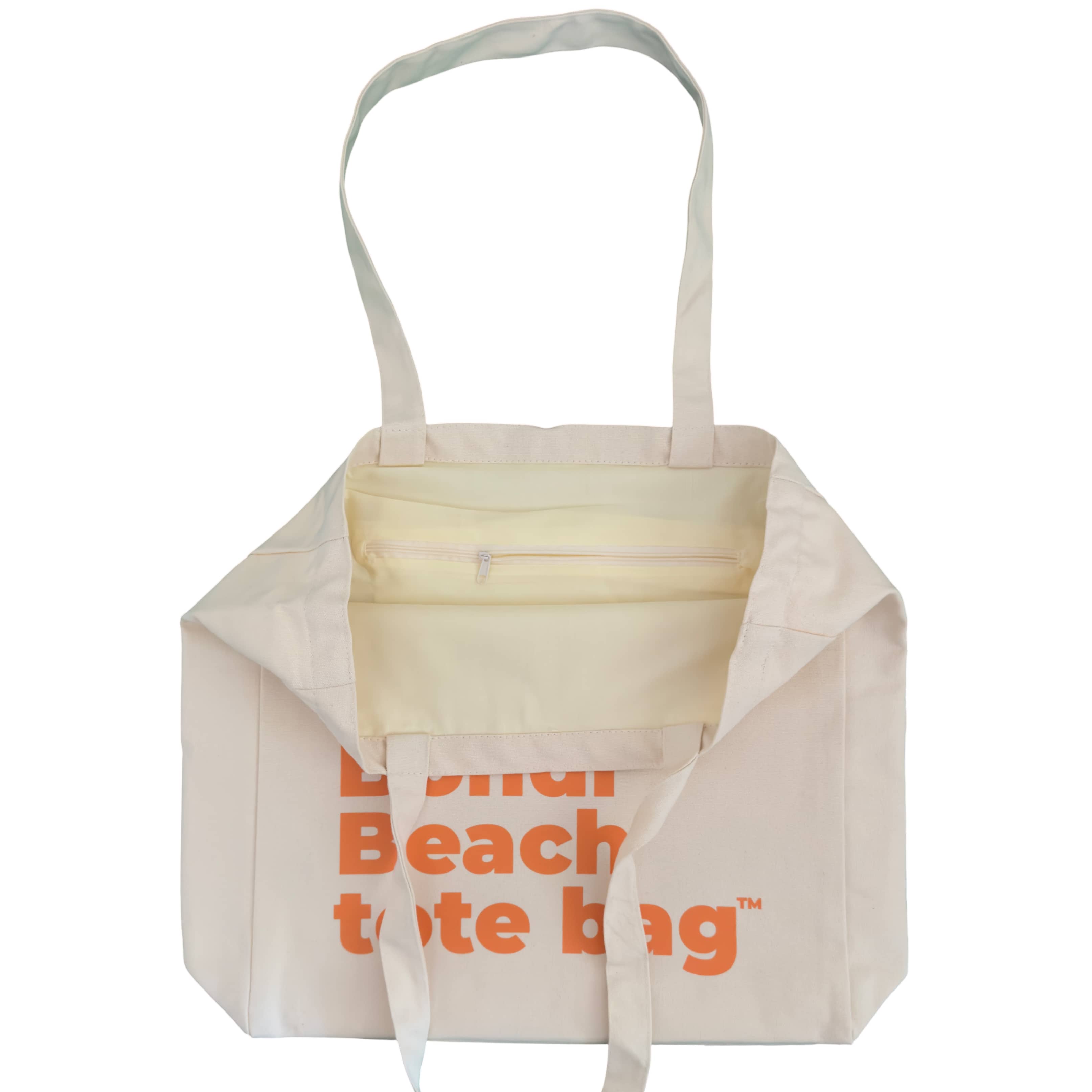 Close-up of a beige tote bag with a zipper pocket.